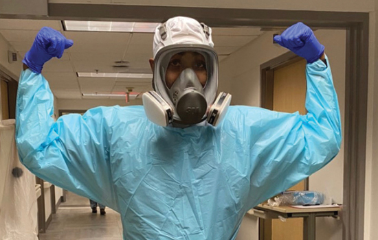 donte flanagan wearing PPE standing in a hospital flexing his arms