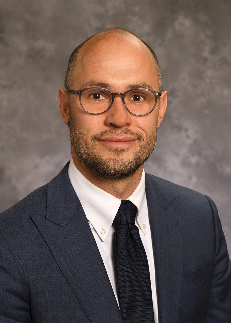 Tim Cunningham wearing a dark tie and dark jacket in a portrait.