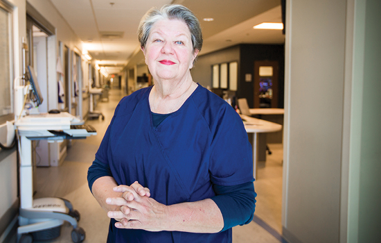 Linda Cross standing in a hospital hallway smiling